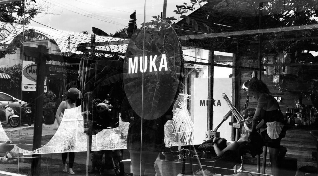 View through window of Muka Concepts Pererenan, showcasing interior and reflections of Bali street, Bali, Bali, ID.