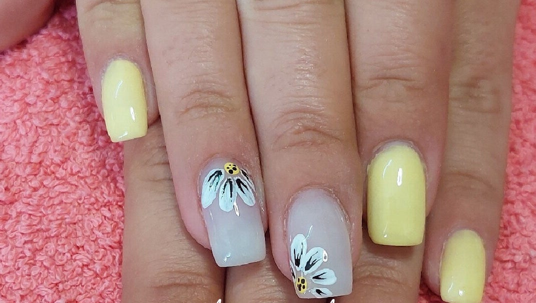 Yellow floral nail art at Melissa's Nails, Centurion, Gauteng, ZA on a pink towel.