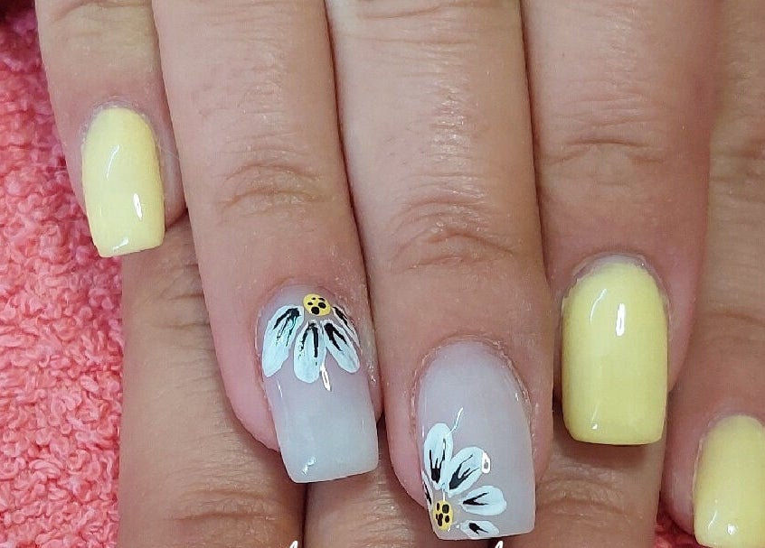 Yellow floral nail art at Melissa's Nails, Centurion, Gauteng, ZA on a pink towel.