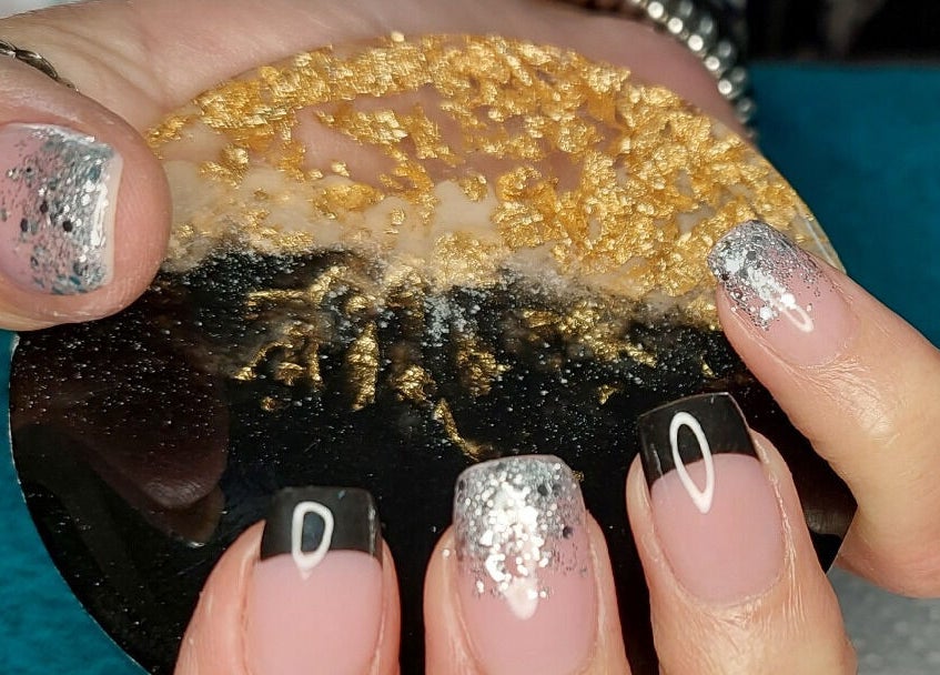 Elegant black and silver nail art at Melissa's Nails, Centurion, Gauteng, ZA with a luxurious, textured coaster.
