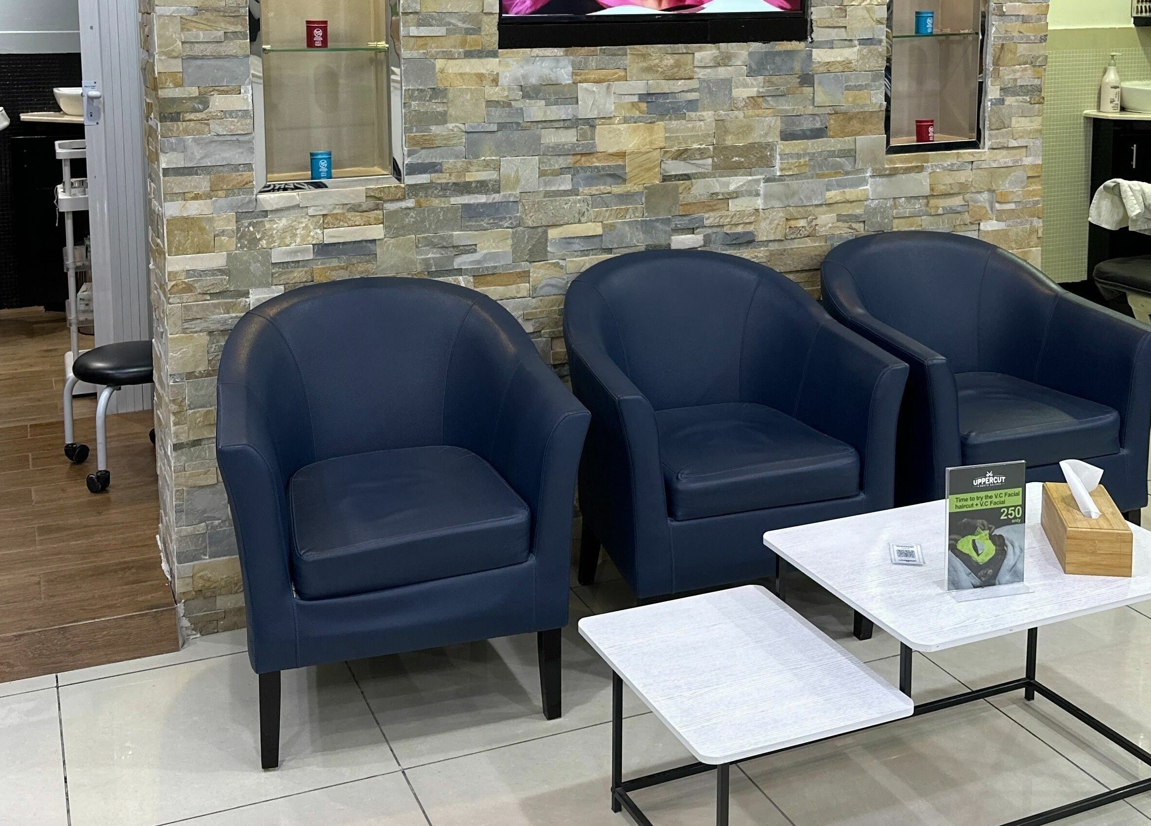 Modern lounge at Uppercut Gents Salon, Jumeirah Beach Residences, Dubai with blue chairs and stylish decor.