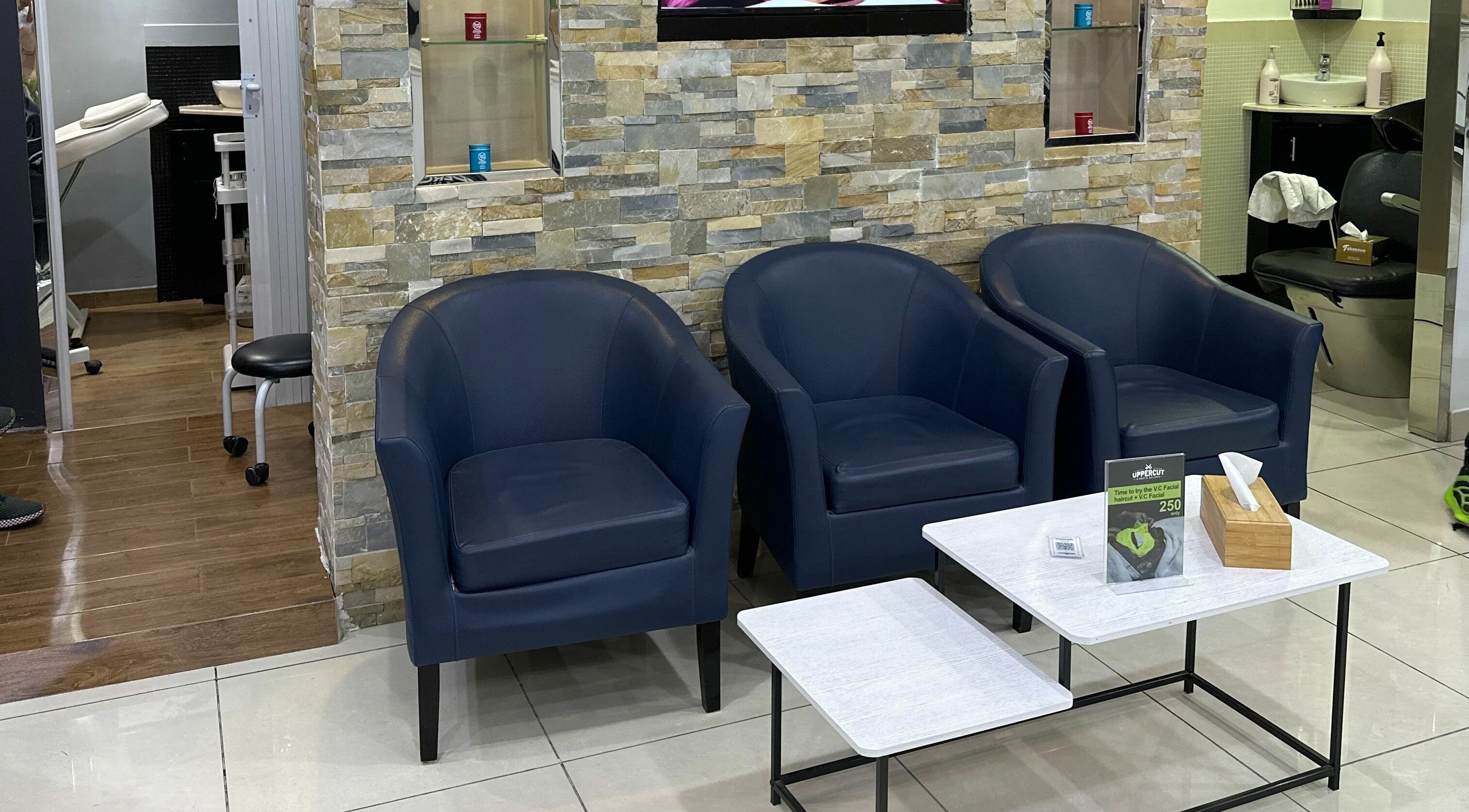 Modern lounge at Uppercut Gents Salon, Jumeirah Beach Residences, Dubai with blue chairs and stylish decor.