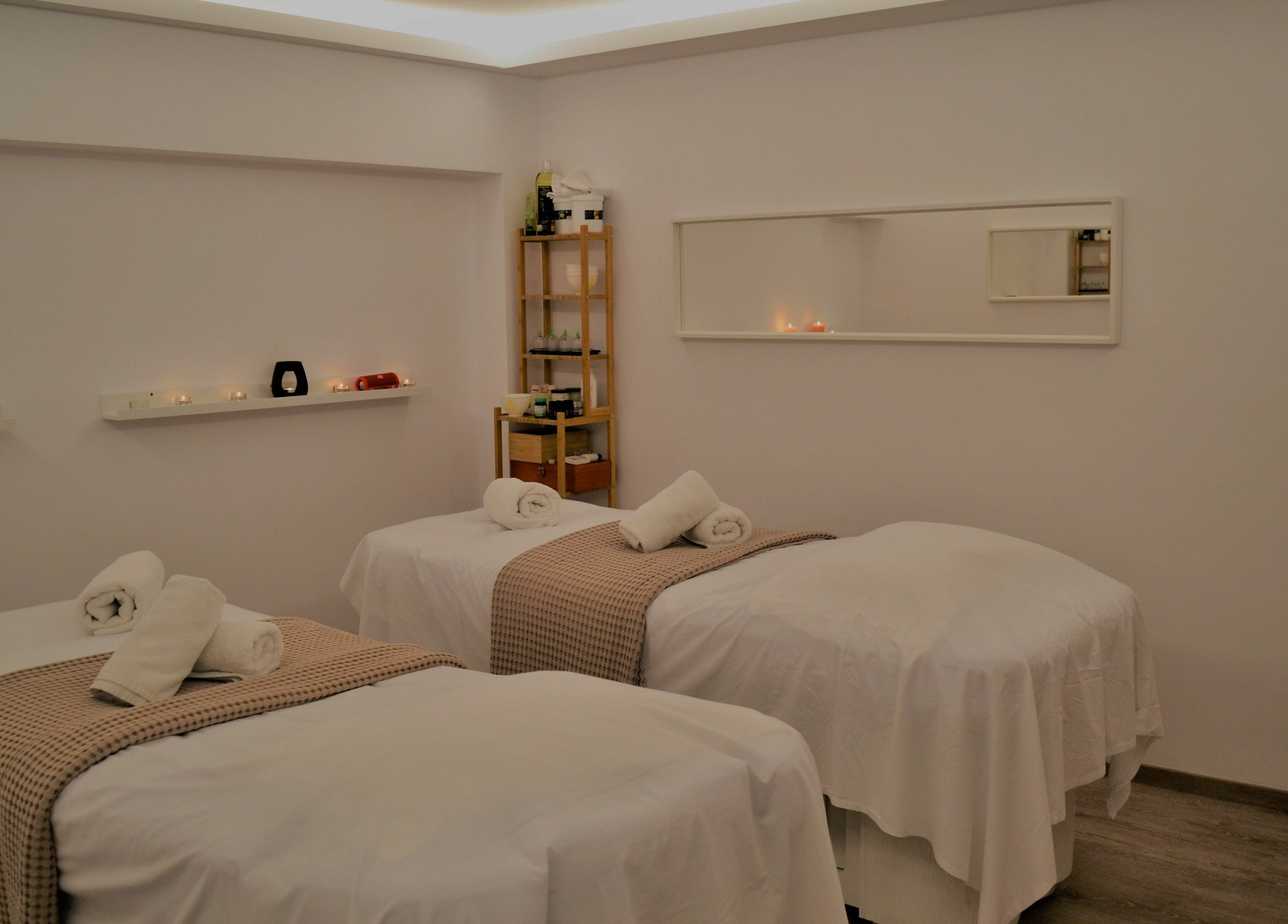 Tranquil massage room at Oh My Spa, Argostoli, GR with three beds and ambient candles.