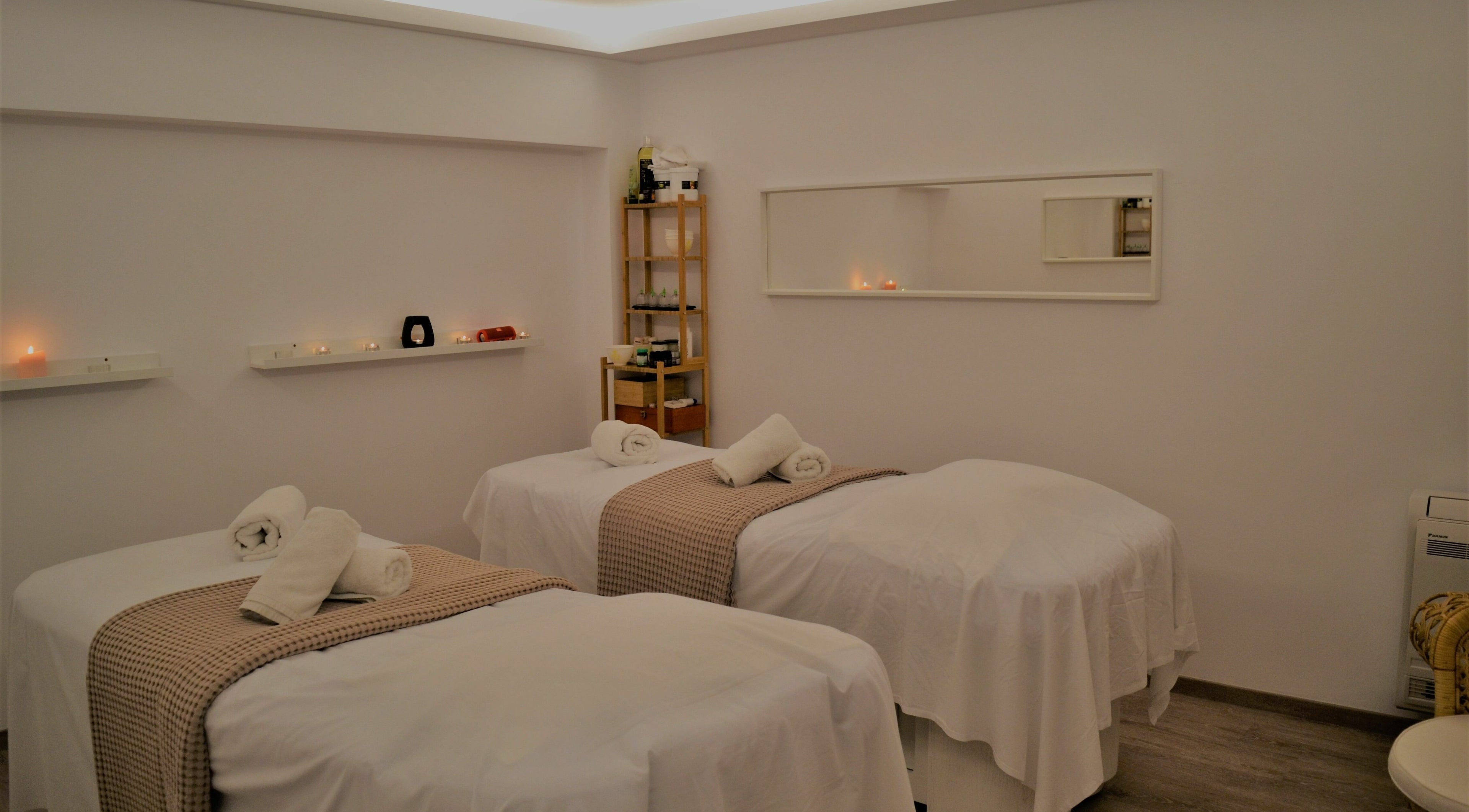 Tranquil massage room at Oh My Spa, Argostoli, GR with three beds and ambient candles.