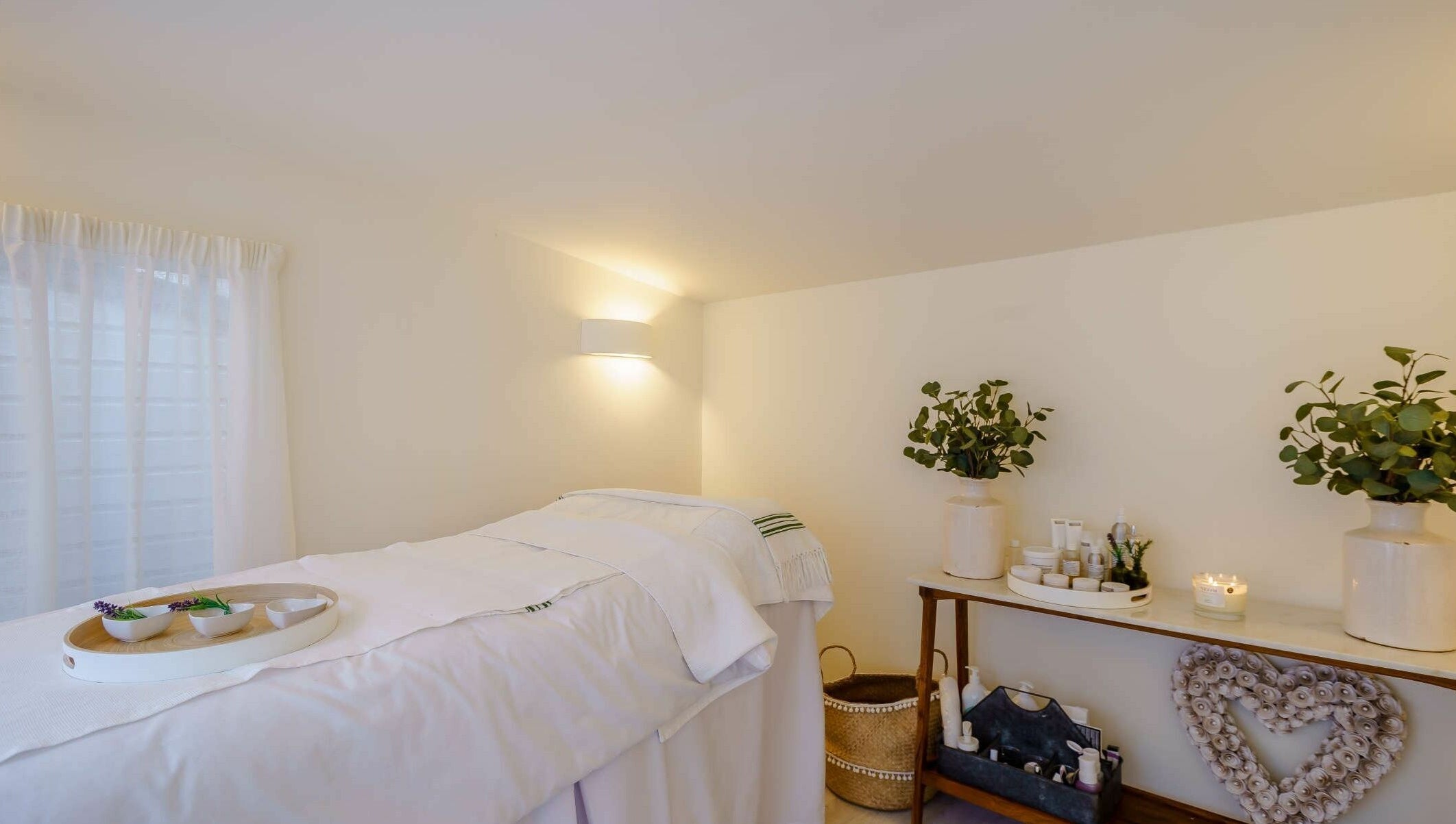The Secret Spa's tranquil treatment room in Holt, Wales, GB featuring a massage table and calming decor.