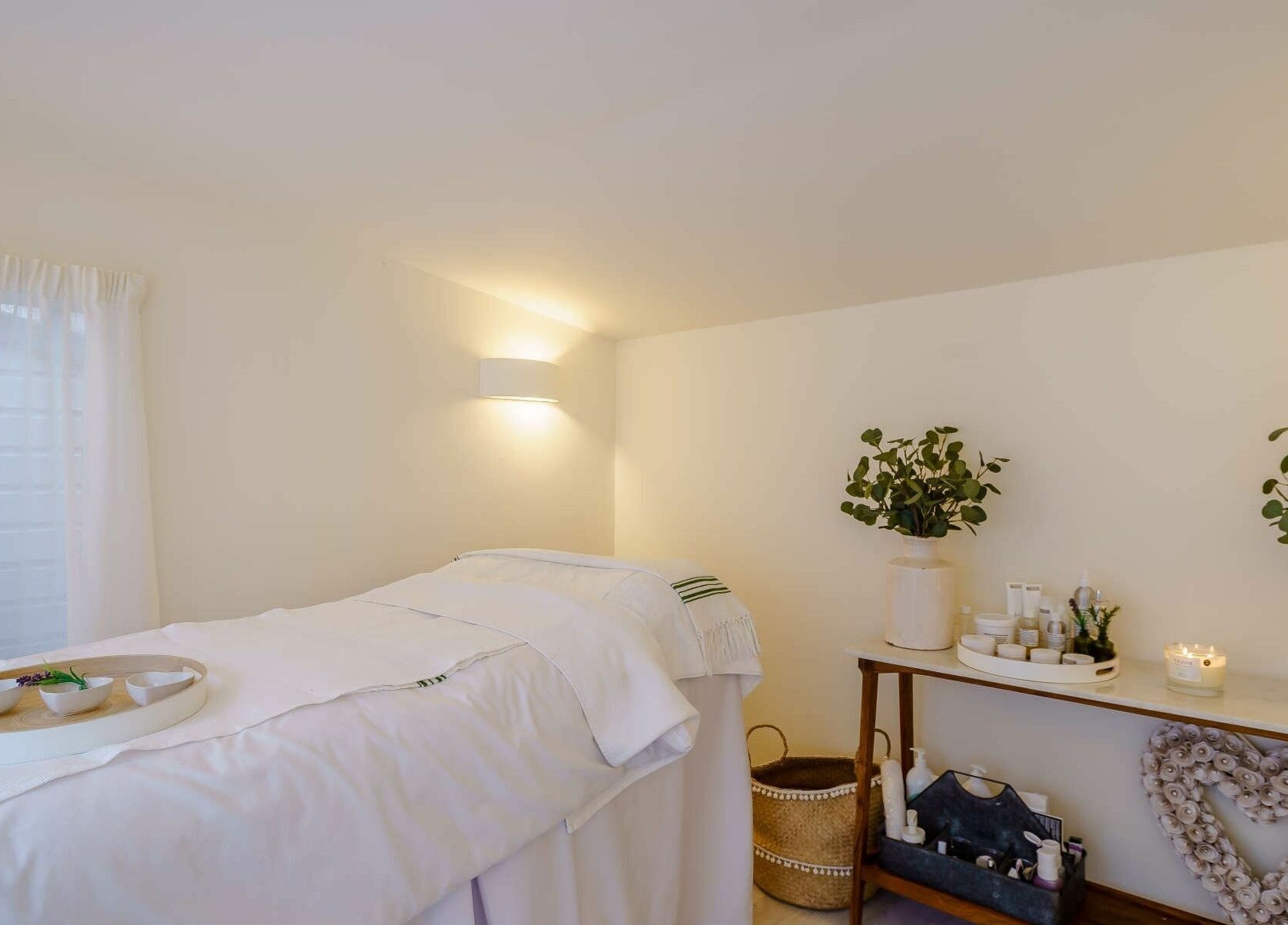 The Secret Spa's tranquil treatment room in Holt, Wales, GB featuring a massage table and calming decor.