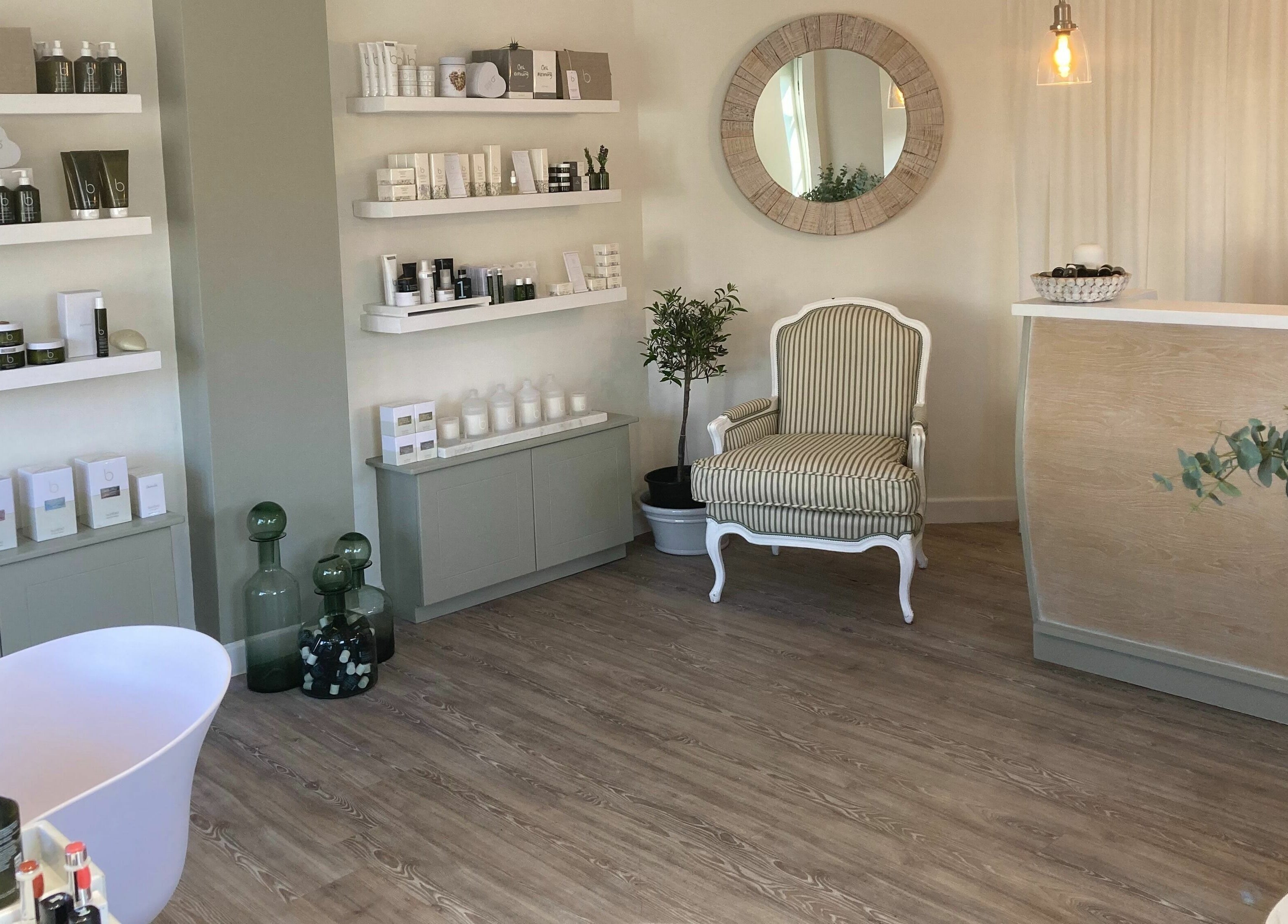 The Secret Spa reception area in Holt, Wales, GB, featuring calm decor with beauty products on display.