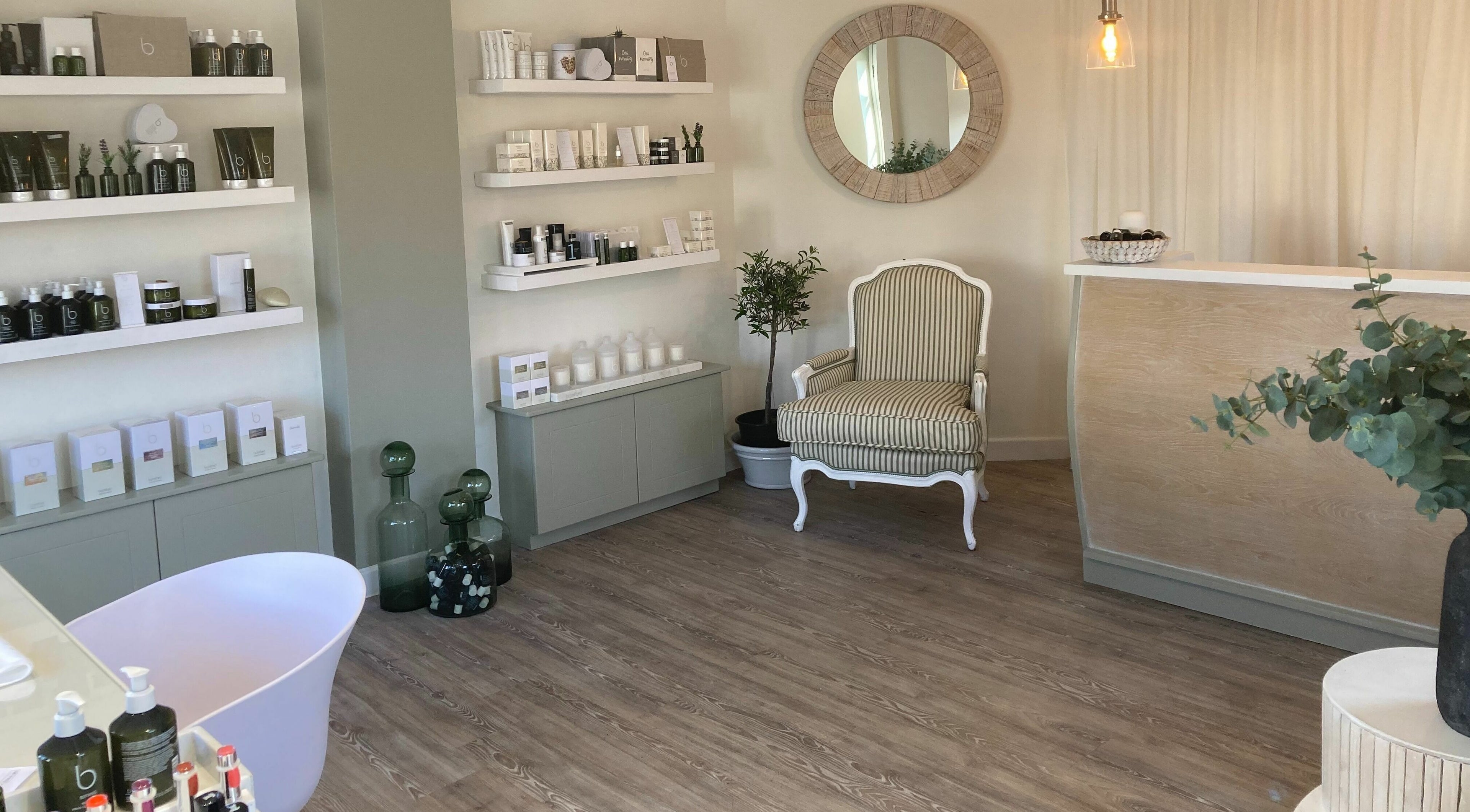 The Secret Spa reception area in Holt, Wales, GB, featuring calm decor with beauty products on display.