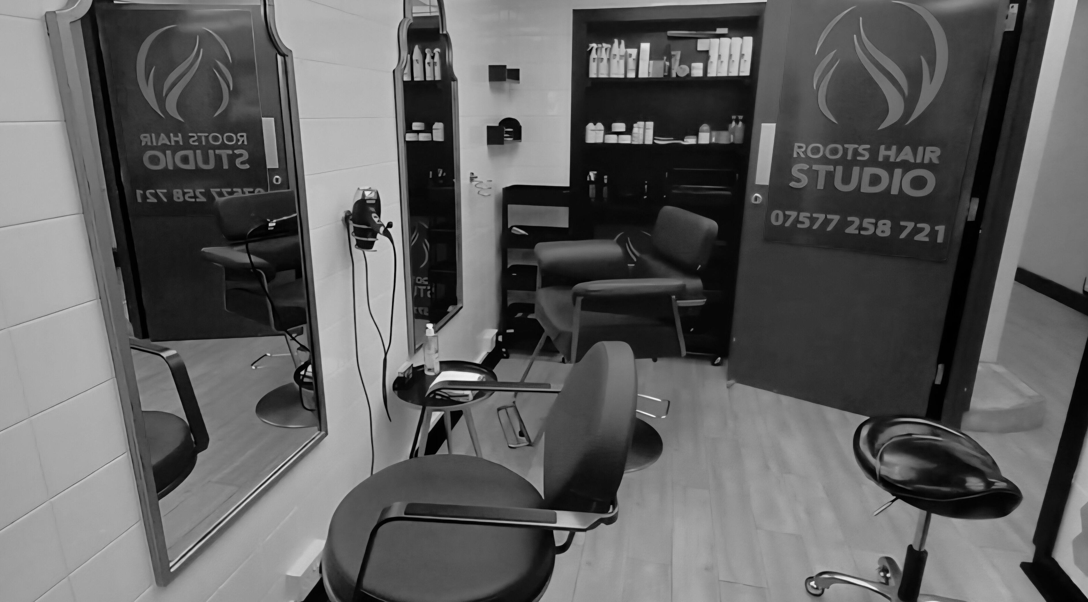 Sleek interior of Roots Hair Studio in Rochester, England, GB, showcasing modern chairs and styling stations.