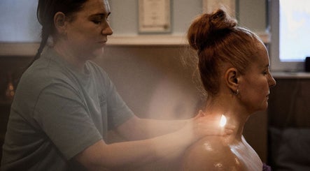 Therapist at Zilda Holistic Therapies in Dunfermline, Scotland, provides soothing massage to a relaxed client.