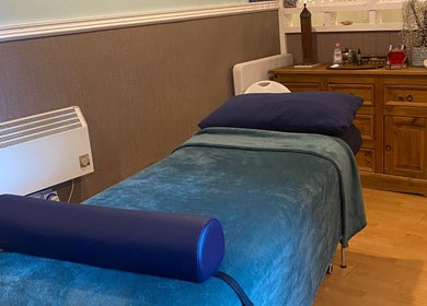 Cozy therapy room at Zilda Holistic Therapies, Dunfermline, Scotland, GB, with a massage bed and wooden cabinet.