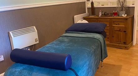 Cozy therapy room at Zilda Holistic Therapies, Dunfermline, Scotland, GB, with a massage bed and wooden cabinet.
