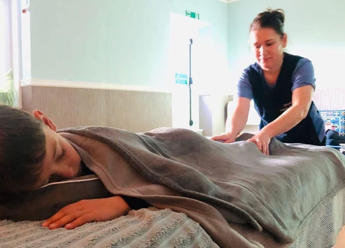 Therapist at Zilda Holistic Therapies in Dunfermline, Scotland, GB, provides a soothing massage to a relaxed client.