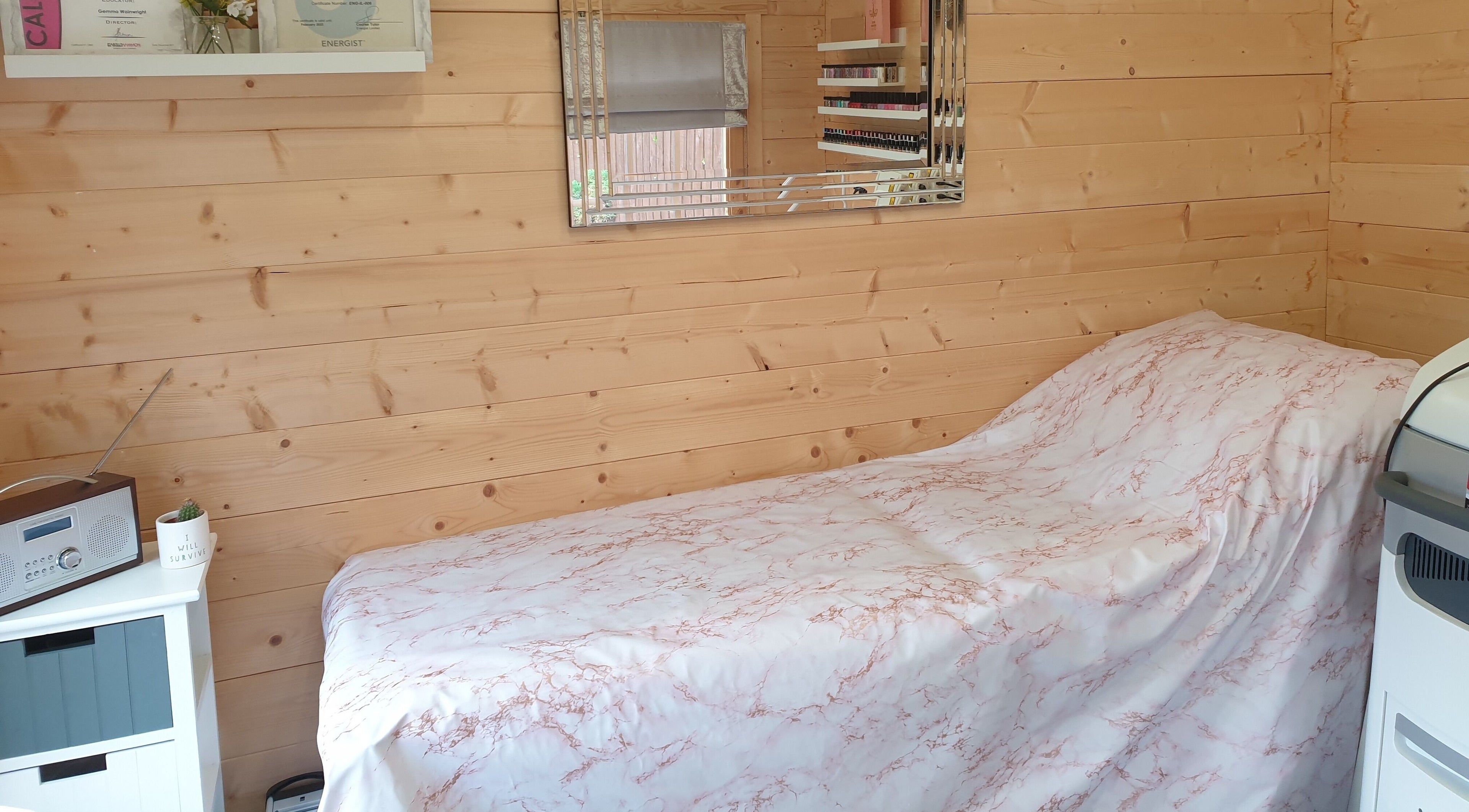 Cozy treatment room at Bella Ness Beauty, Inverness, Scotland, GB with wooden walls and soft pink cover.