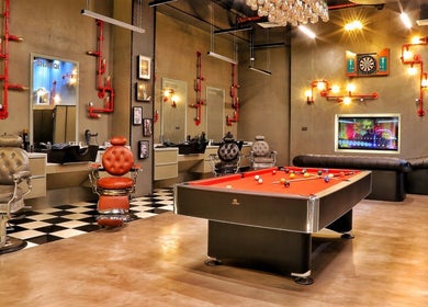 Elegant interior of Sharqi Gents Salon in Sharjah, AE featuring barber chairs and a pool table.