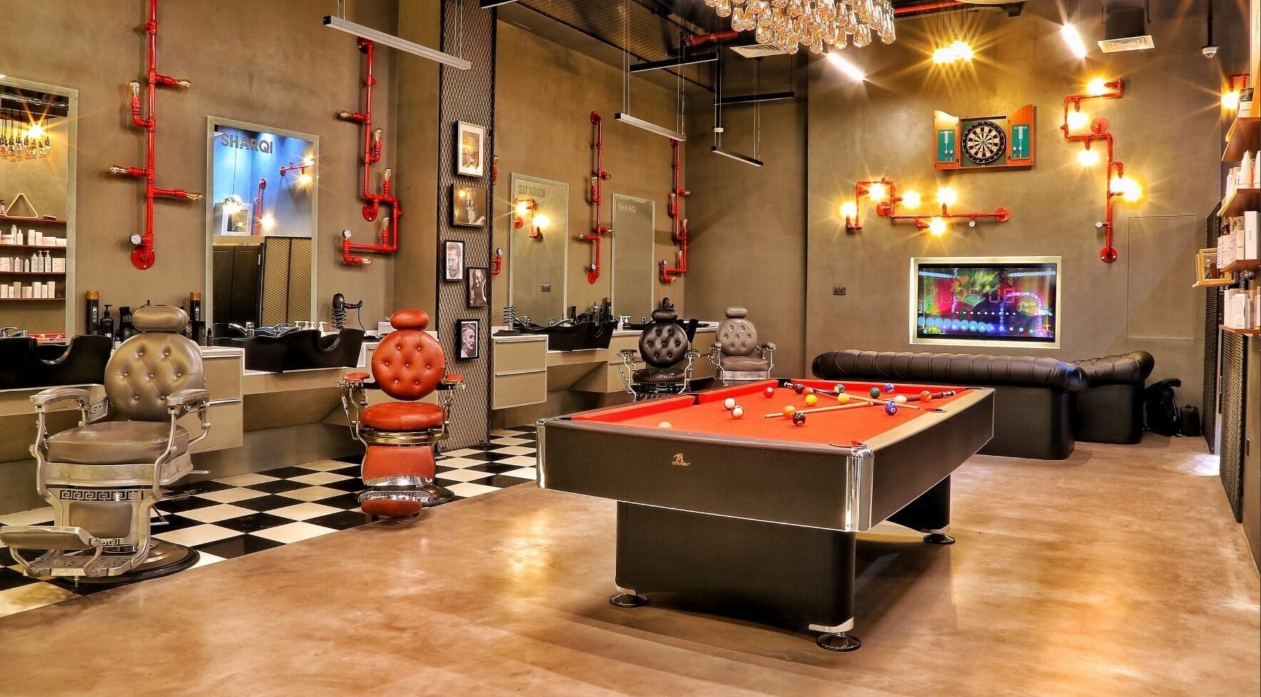 Elegant interior of Sharqi Gents Salon in Sharjah, AE featuring barber chairs and a pool table.