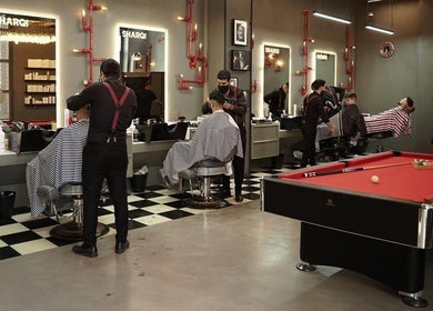 Interior of Sharqi Gents Salon in Sharjah, AE featuring haircuts and a pool table for client relaxation.