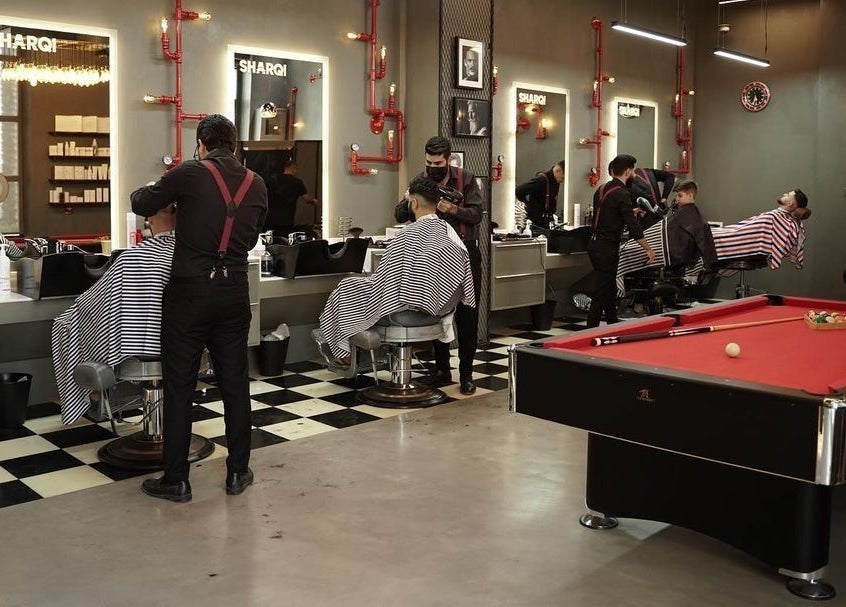Interior of Sharqi Gents Salon in Sharjah, AE featuring haircuts and a pool table for client relaxation.