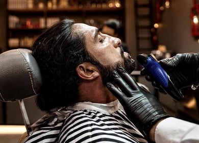 Professional beard trim at Sharqi Gents Salon, Sharjah, AE. Barber skillfully shapes a client's beard.