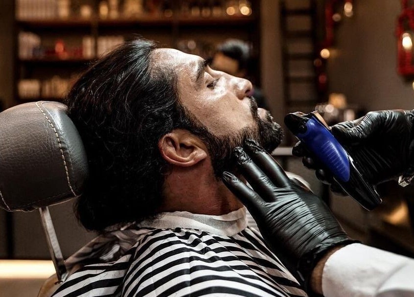 Professional beard trim at Sharqi Gents Salon, Sharjah, AE. Barber skillfully shapes a client's beard.