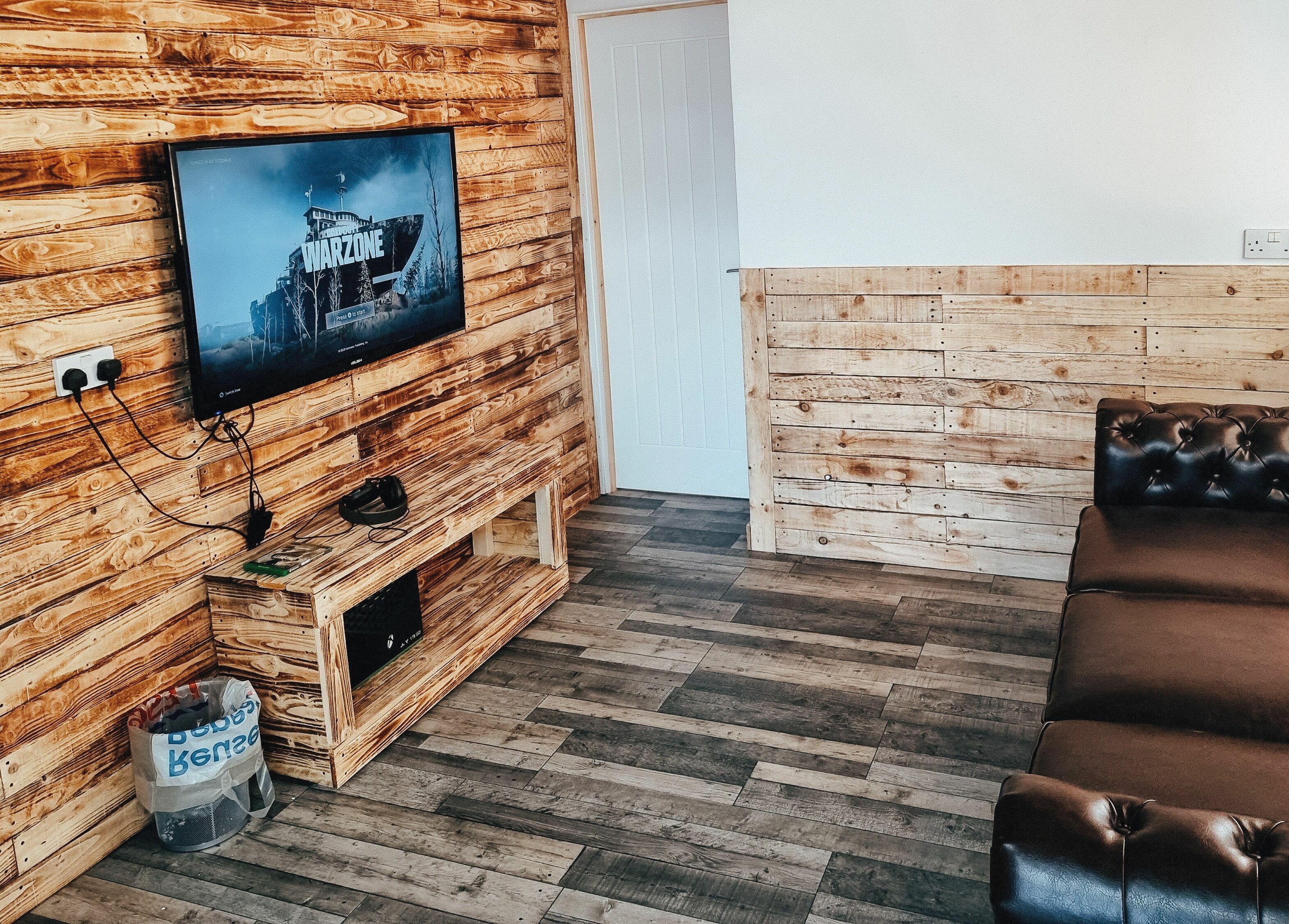 Cozy lounge with leather sofa at The Barber Lounge, Talbot Green, Wales, GB featuring a wooden panel decor.