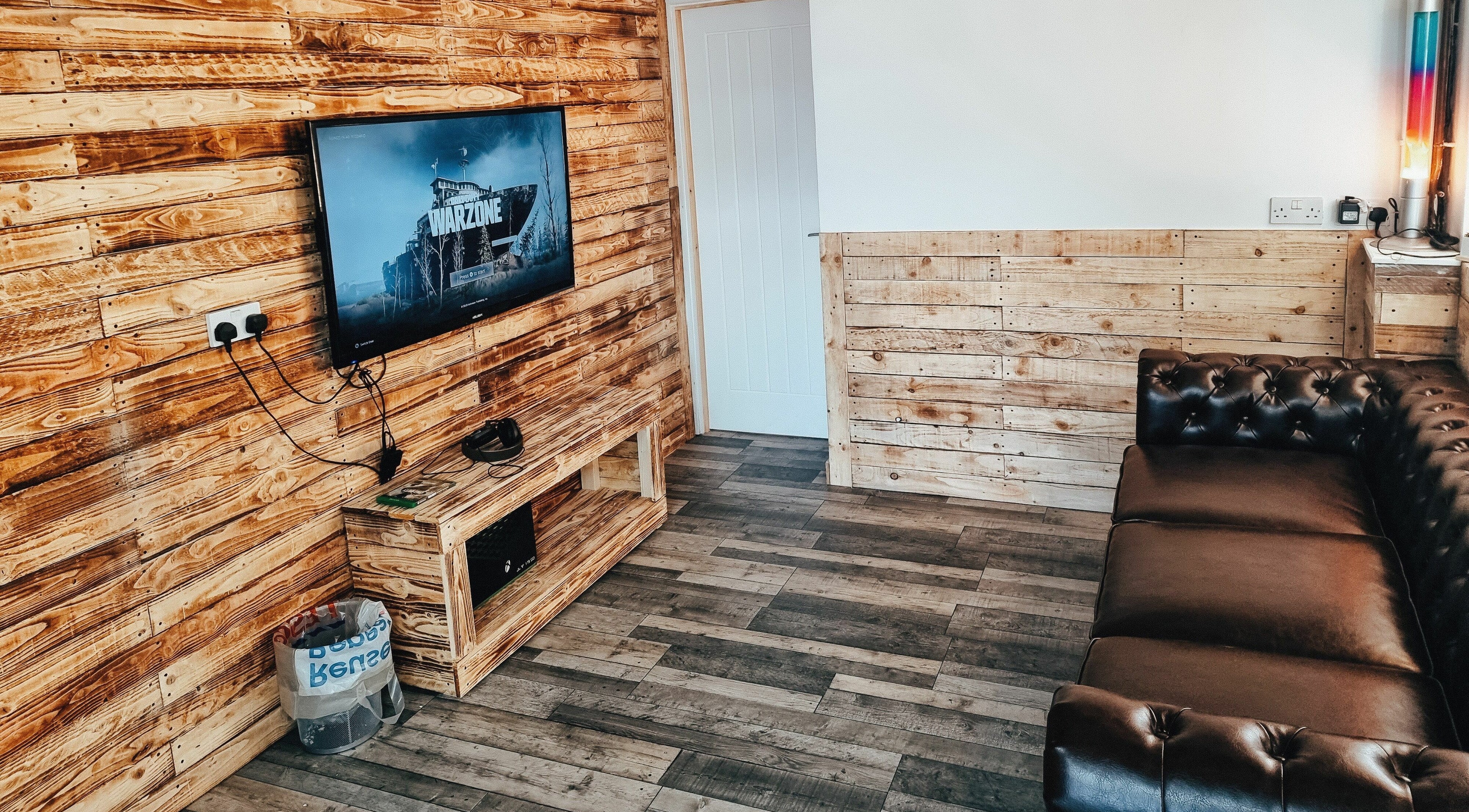 Cozy lounge with leather sofa at The Barber Lounge, Talbot Green, Wales, GB featuring a wooden panel decor.