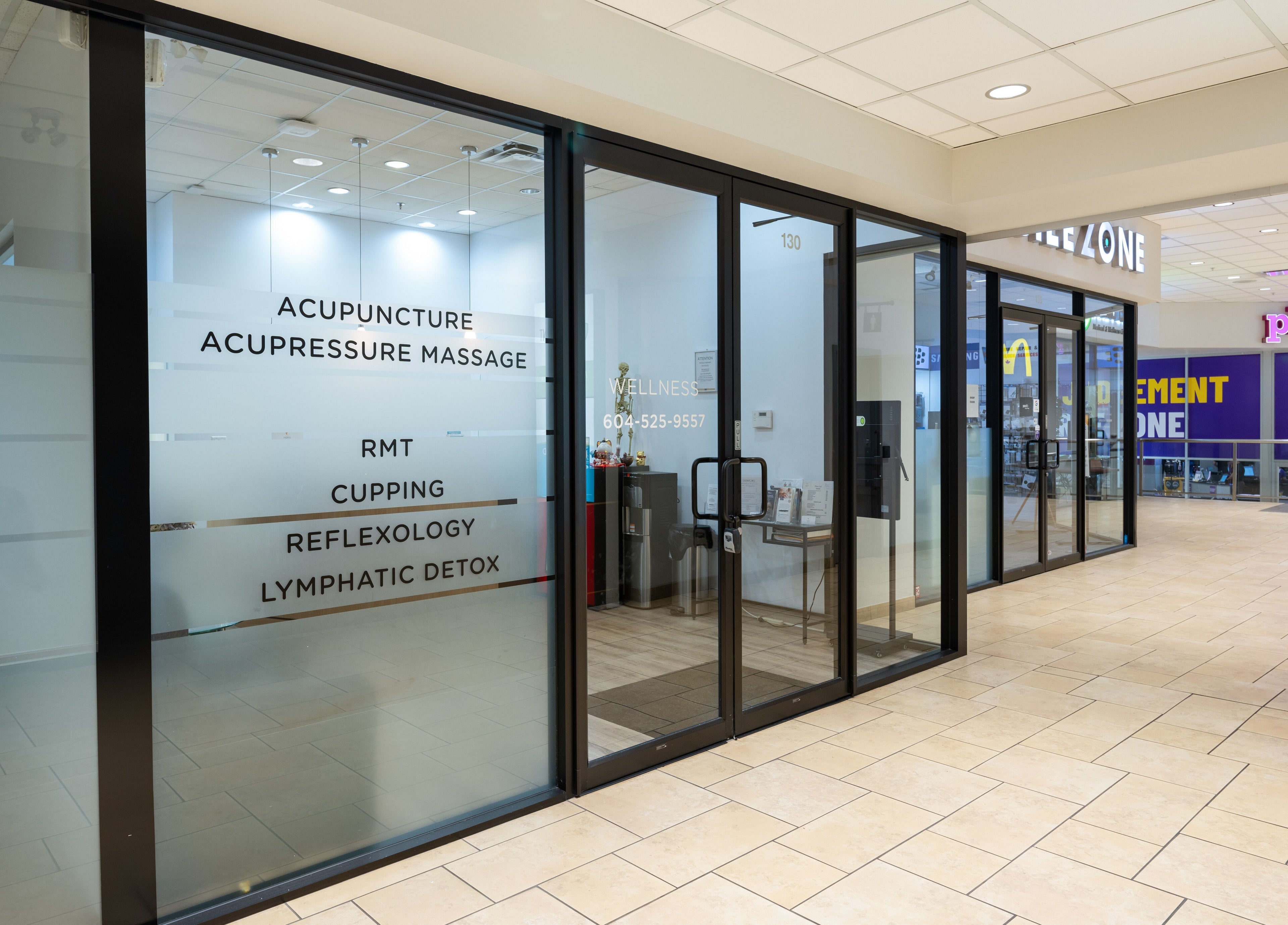 Glass storefront of Nano Beauty in New Westminster, BC, offering acupuncture, massage, and wellness services.