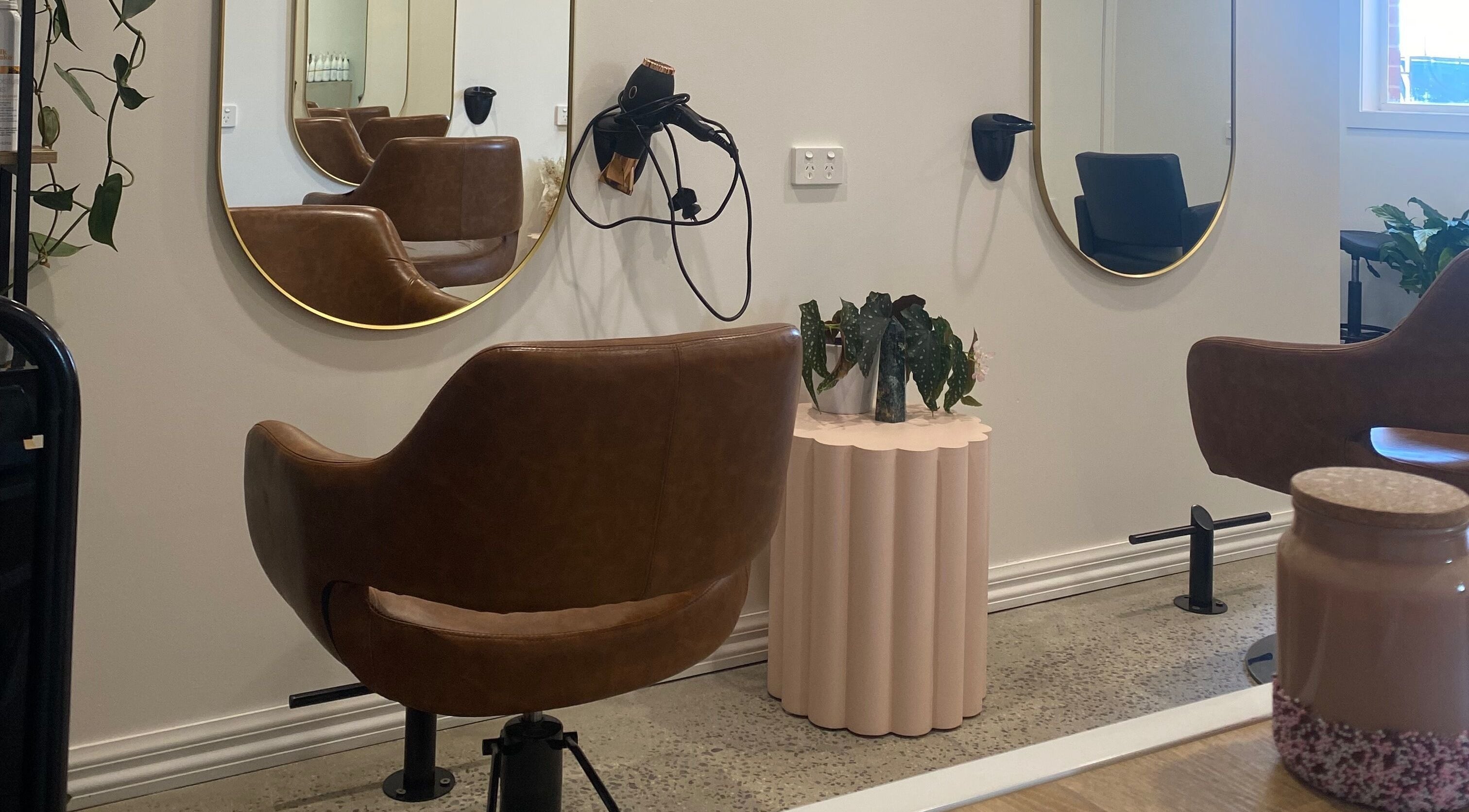 Stylish salon interior at Nixaura Hair, Melbourne, Victoria, AU with elegant chairs and mirrors.