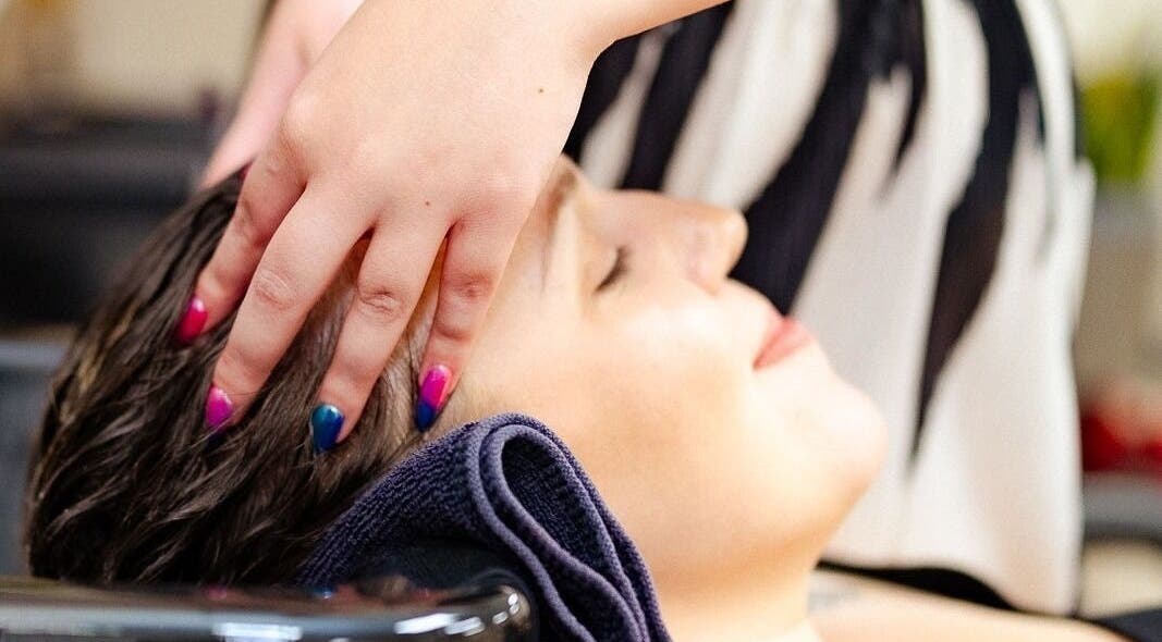 Customer enjoying a soothing scalp massage at Hair by Holly Way, Owen Sound, Ontario, CA.