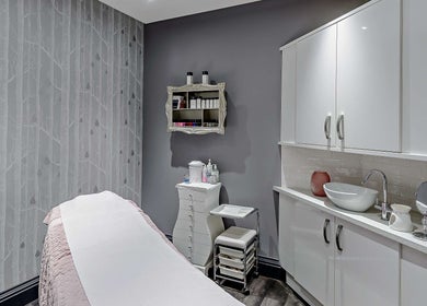 Elegant treatment room at Chewys Collective, Gloucester, England, GB, featuring a cozy massage bed and chic decor.