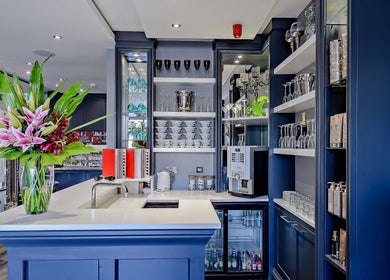 Sophisticated bar area in Chewys Collective, Gloucester, England, GB with stylish shelving and floral decor.