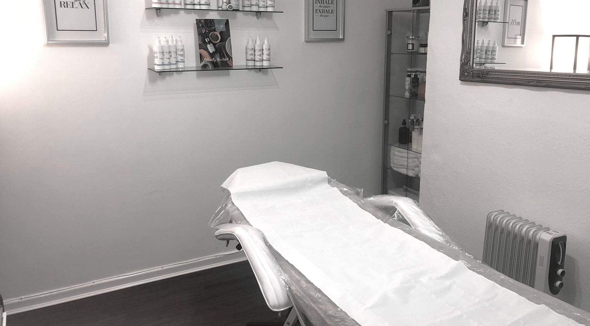 A serene treatment room at Enhanced Beauty and Well-Being in Swindon, England, GB with a neatly prepared bed.