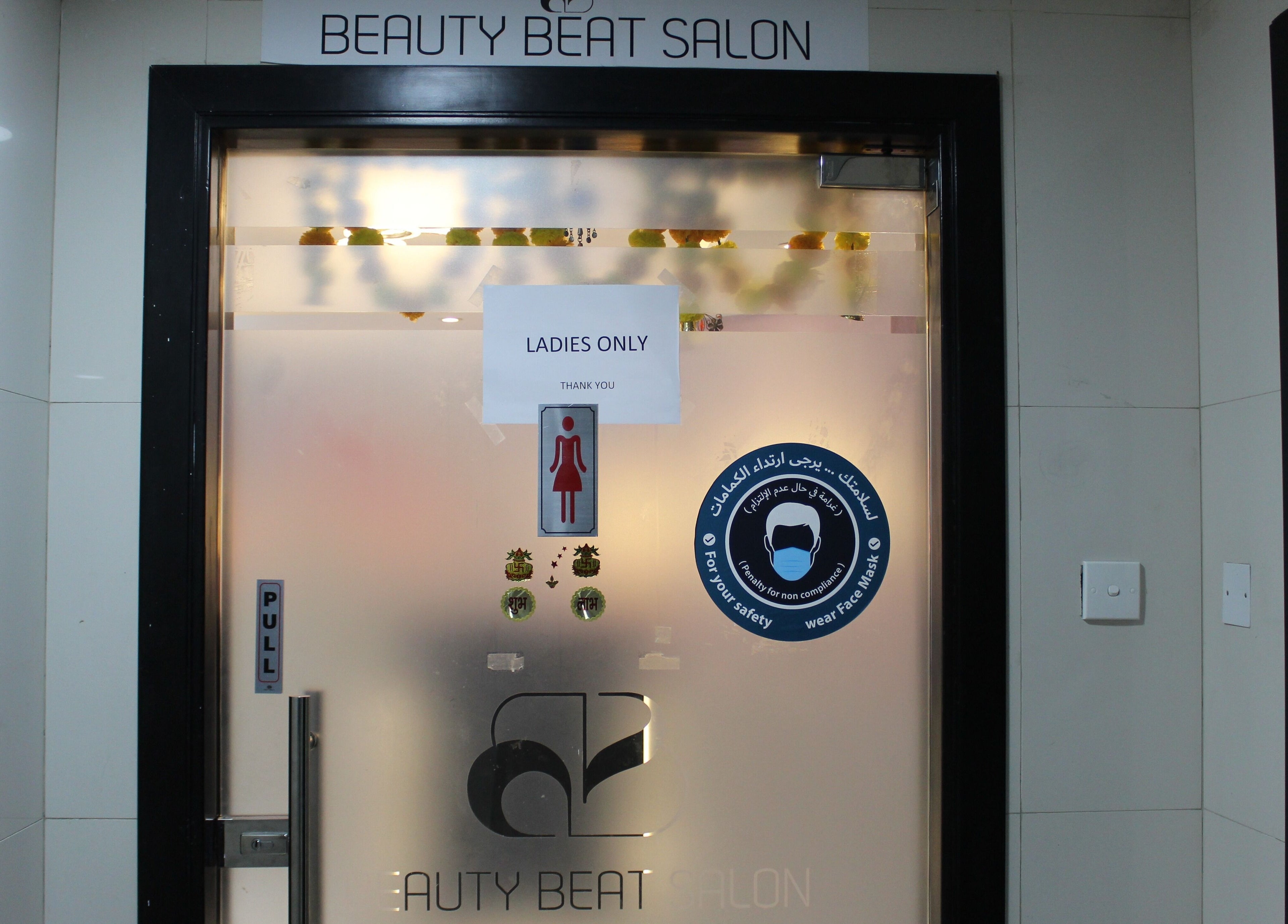 Entrance to Beauty Beat DMCC in Dubai with frosted glass and signage. Ladies only policy at Dubai, Dubai, AE.