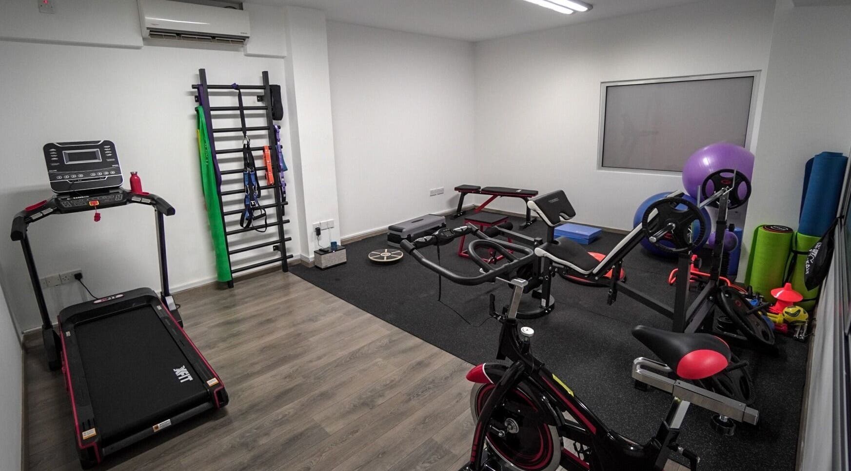 Gym equipment at Physio Vichas, Λατσιά, Λευκωσία, CY featuring treadmill, cycle, and workout gear.