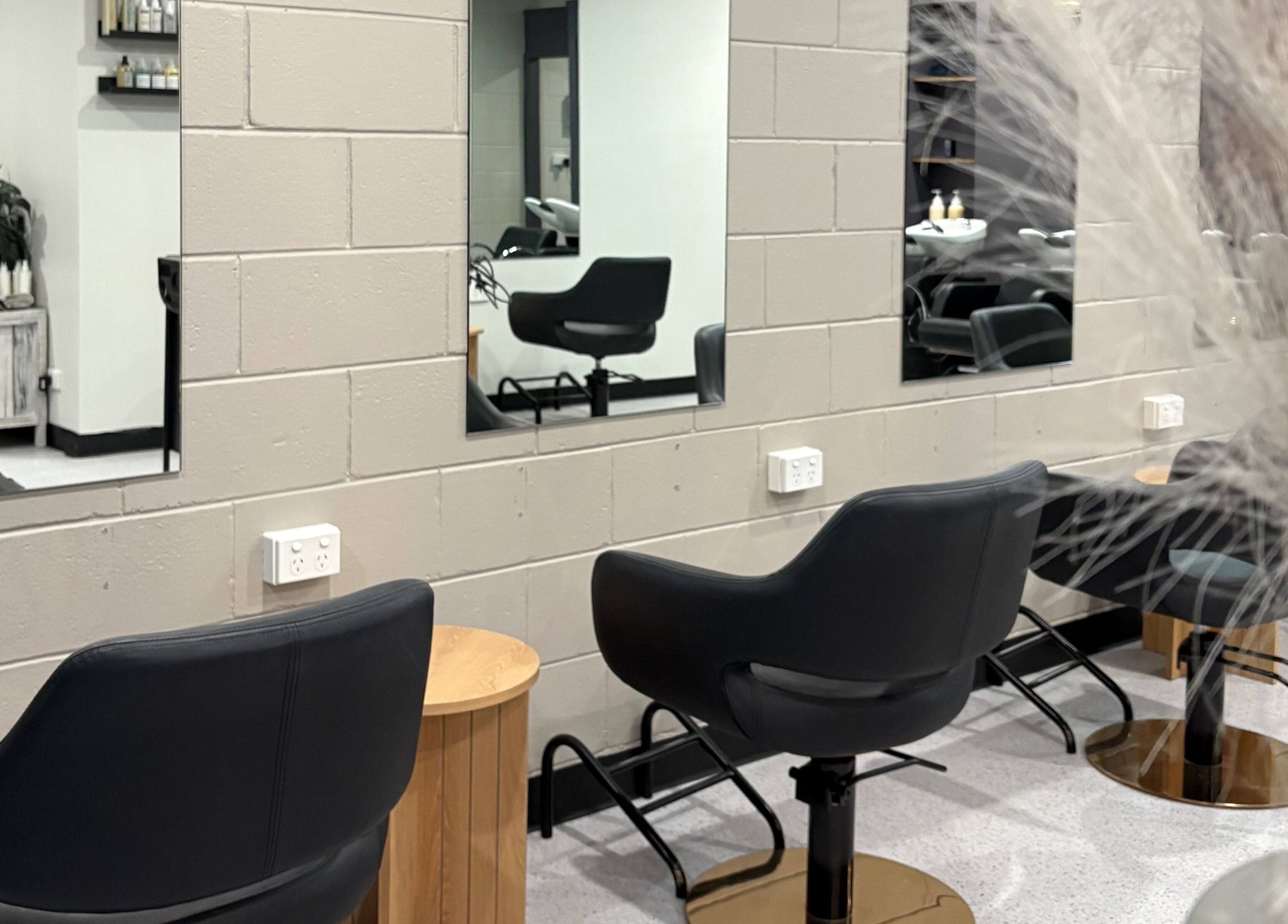 Elegant salon chairs and mirrors at The Hair Collective - Arana Hills, Queensland, AU.