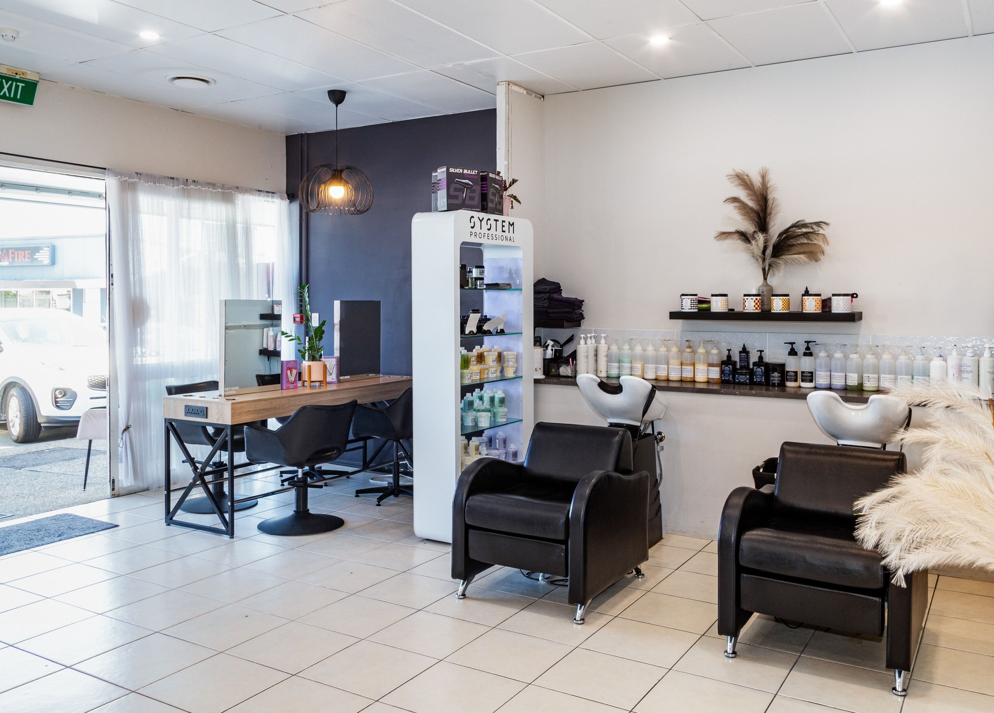 Modern salon at The Hair Collective - Aesthetics Co. in Helensvale, Queensland, AU showcasing styling chairs and products.