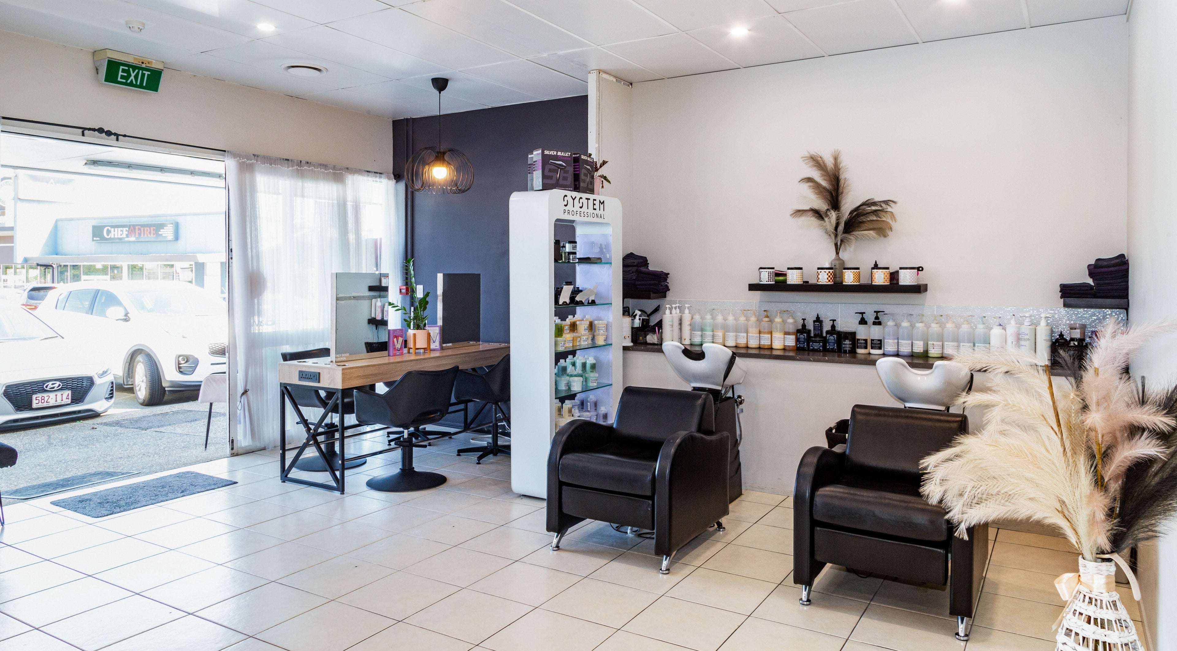 Modern salon at The Hair Collective - Aesthetics Co. in Helensvale, Queensland, AU showcasing styling chairs and products.