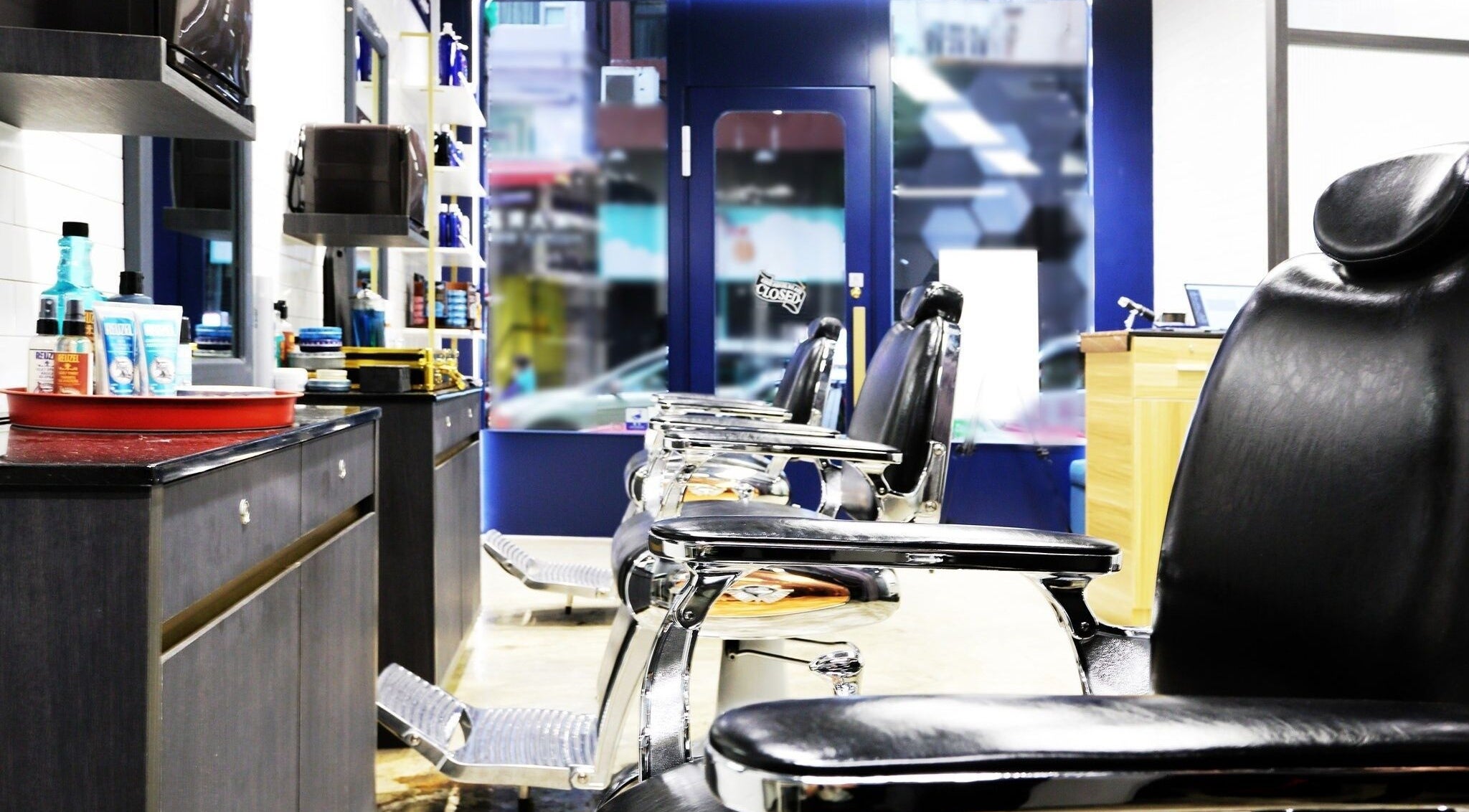 Interior of Dudes Barbershop in Sheung Wan, Hong Kong Island with stylish chairs and grooming products.