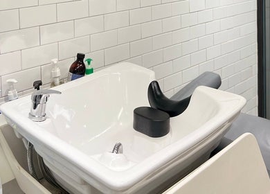 Modern washbasin at Dudes Barbershop, Sheung Wan, Hong Kong Island, HK, set against stylish white tiles.