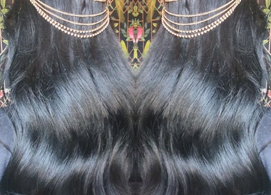 Shiny black hair with gold chains at Moon Hair, East Ardsley, England, GB.
