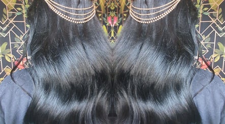 Shiny black hair with gold chains at Moon Hair, East Ardsley, England, GB.