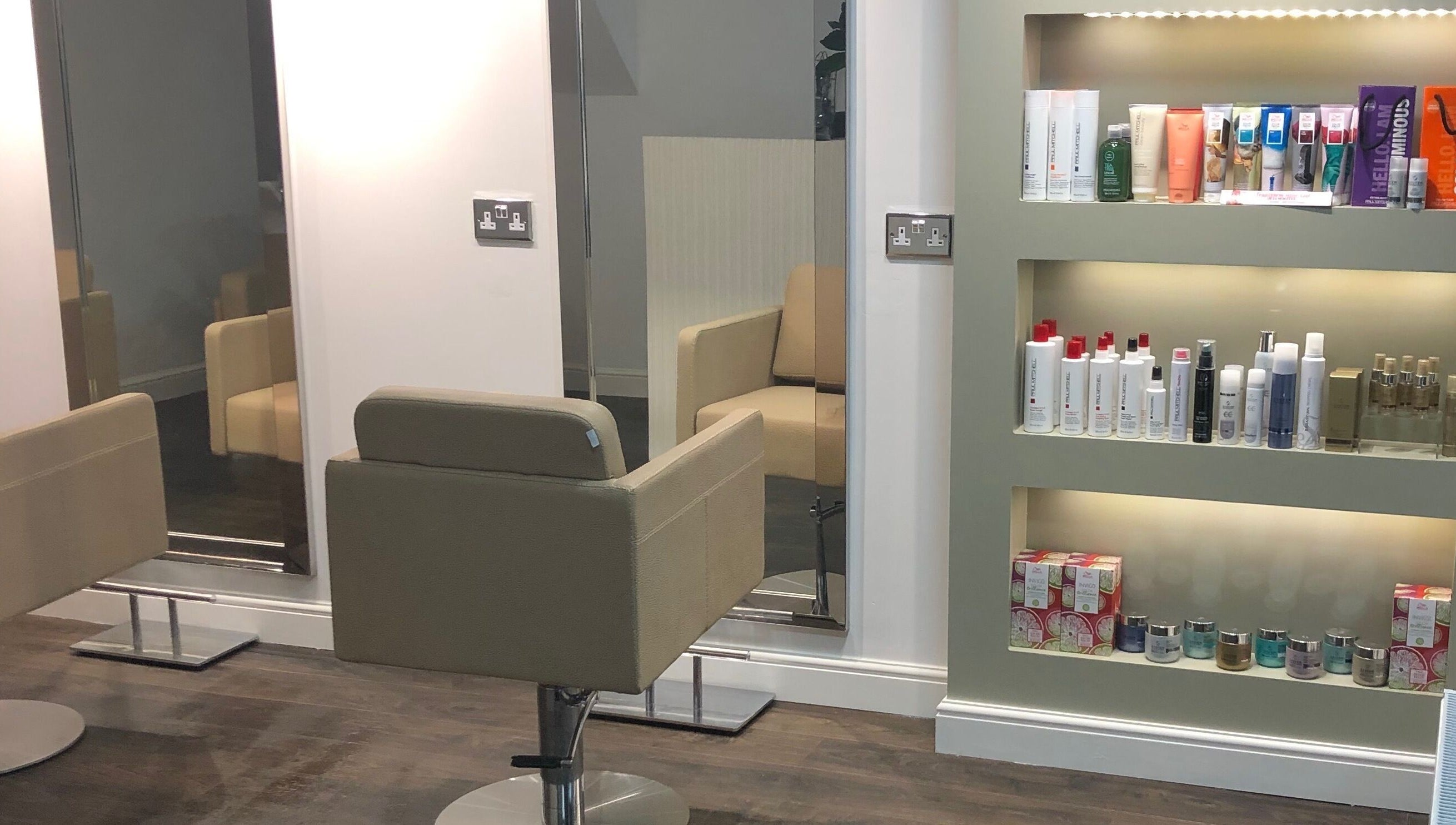Elegant salon chairs and a product display at The Salon Holt, Holt, Wales, GB, showcasing a modern interior.