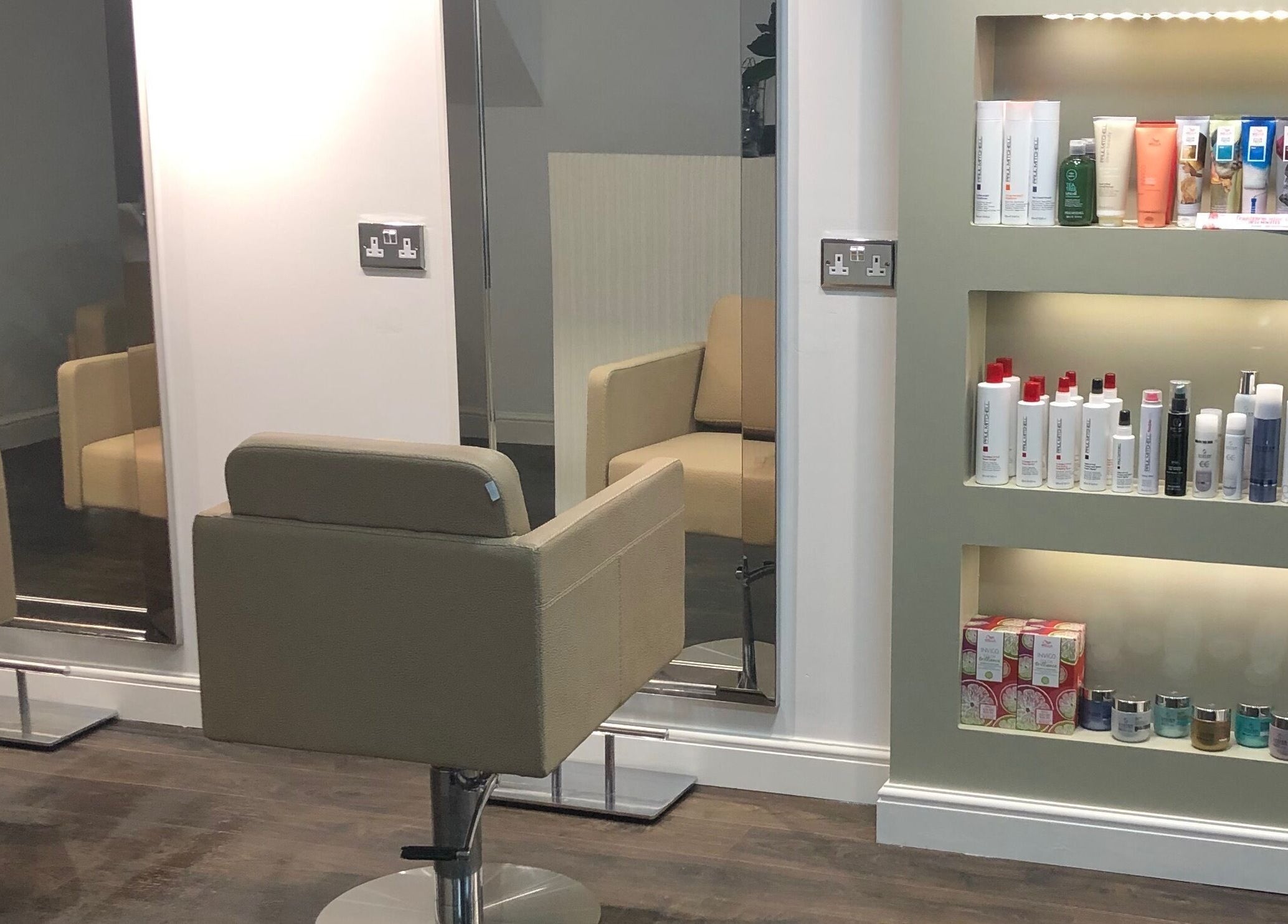 Elegant salon chairs and a product display at The Salon Holt, Holt, Wales, GB, showcasing a modern interior.