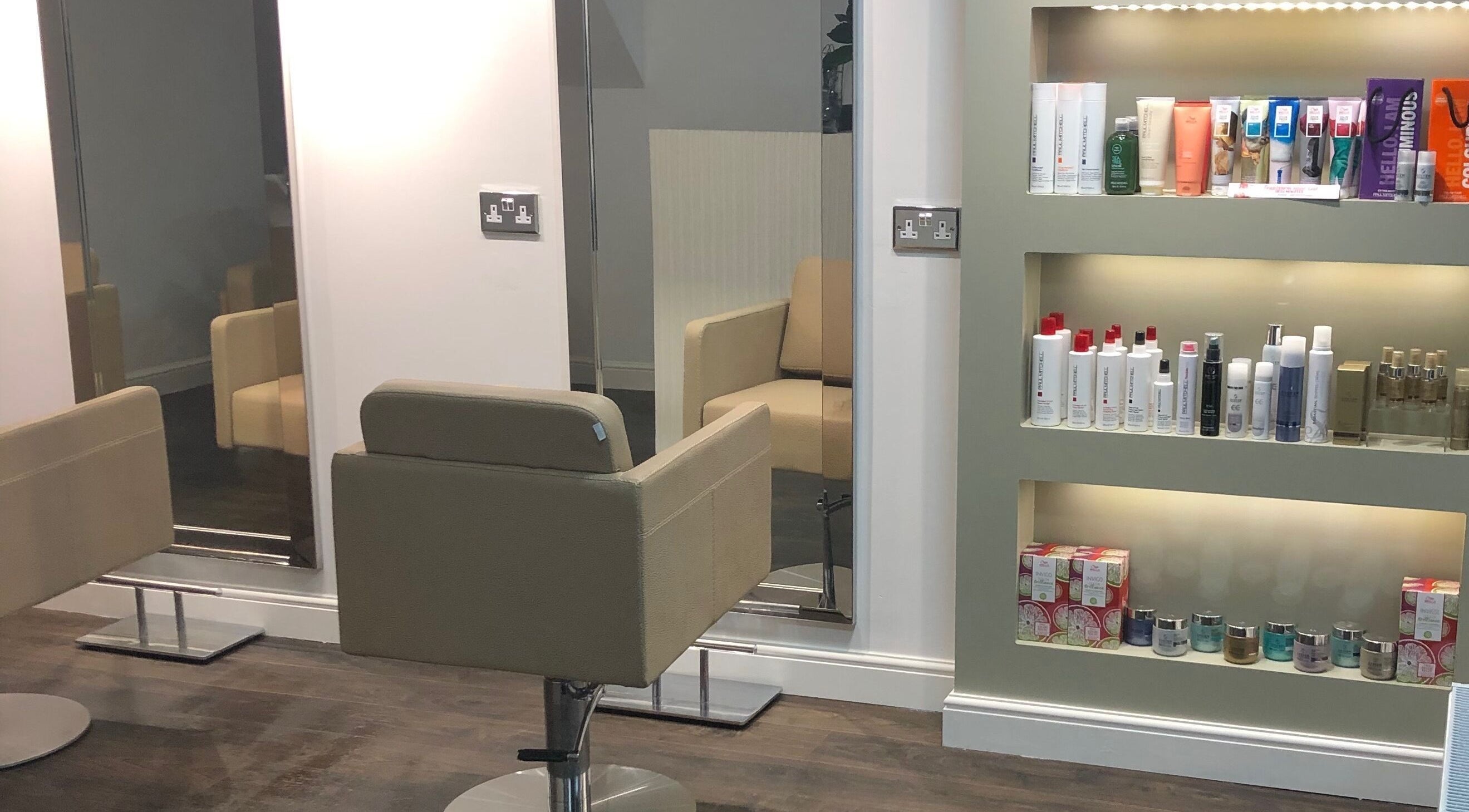 Elegant salon chairs and a product display at The Salon Holt, Holt, Wales, GB, showcasing a modern interior.