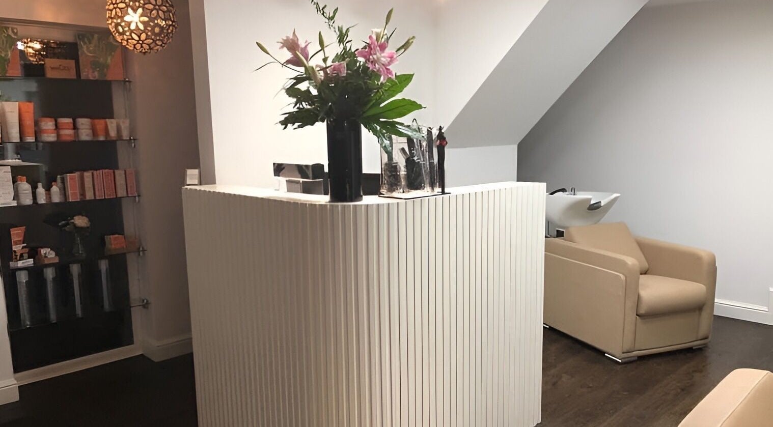 Reception area at The Salon Holt, featuring a stylish desk and plush seating in Holt, Wales, GB.