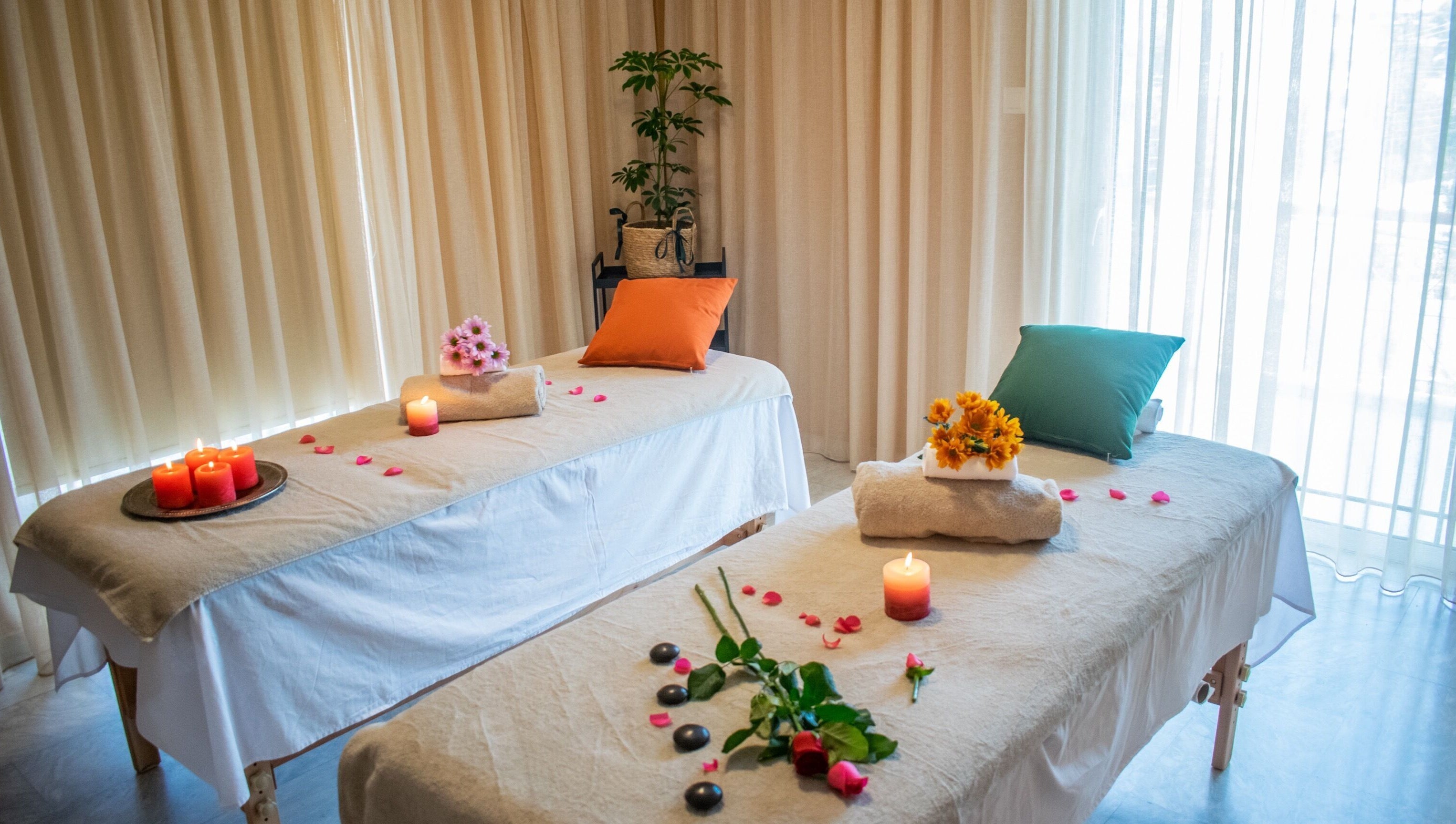 Δύο τραπέζια μασάζ στο Harmony Spa, Μαρούσι, GR με κεριά και λουλούδια.