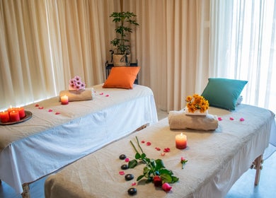 Δύο τραπέζια μασάζ στο Harmony Spa, Μαρούσι, GR με κεριά και λουλούδια.