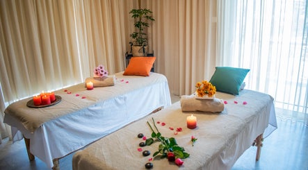 Δύο τραπέζια μασάζ στο Harmony Spa, Μαρούσι, GR με κεριά και λουλούδια.