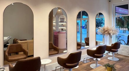 Elegant salon interior at Holly Rose Hair, Sydney, New South Wales, AU with plush chairs and arched mirrors.
