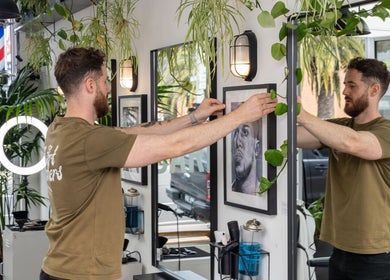 Stylish interior of The Art Barbers St Kilda with vibrant plants in Melbourne, Victoria, AU.